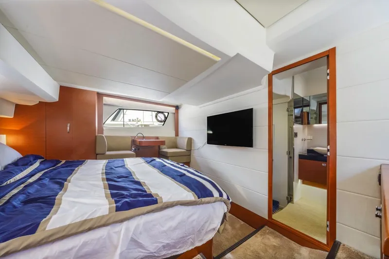 Slide: The Image of Luxurious cabin interior of 2015 Prestige 500FB yacht with bed, TV, and seating area. - 48