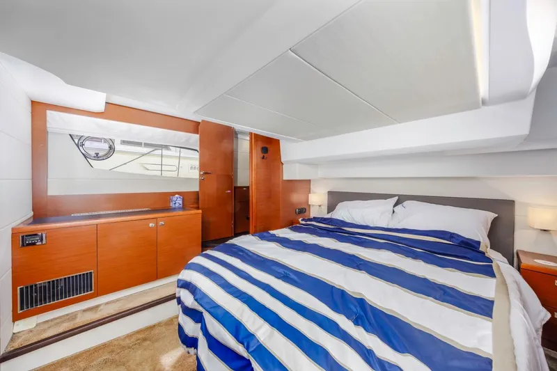 Slide: The Image of Luxurious cabin interior of 2015 Prestige 500FB yacht with striped bedding and wooden accents. - 53
