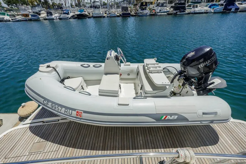Slide: The Image of Inflatable boat with Tohatsu motor docked at marina, surrounded by yachts. - 61