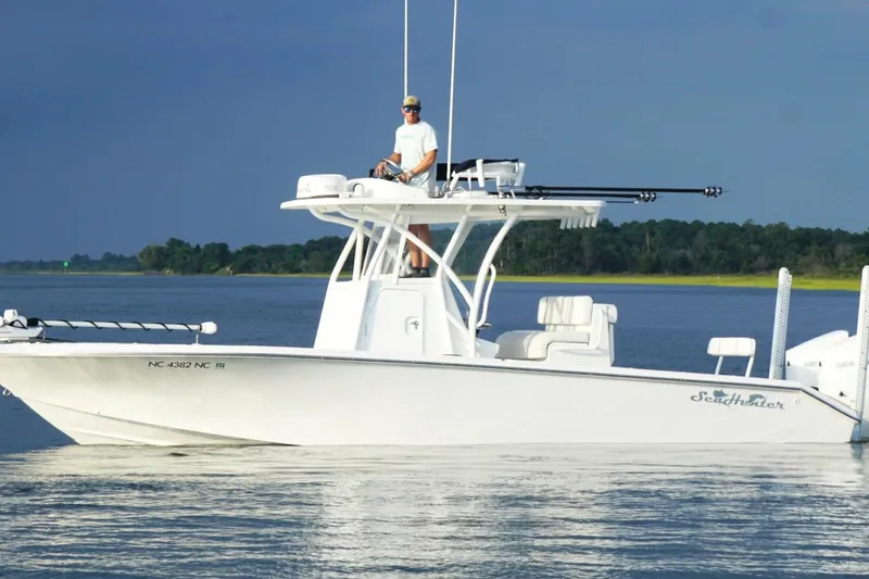 Slide: The Image of 2022 SeaHunter 28 Floridian boat on calm water with person at helm. - 0