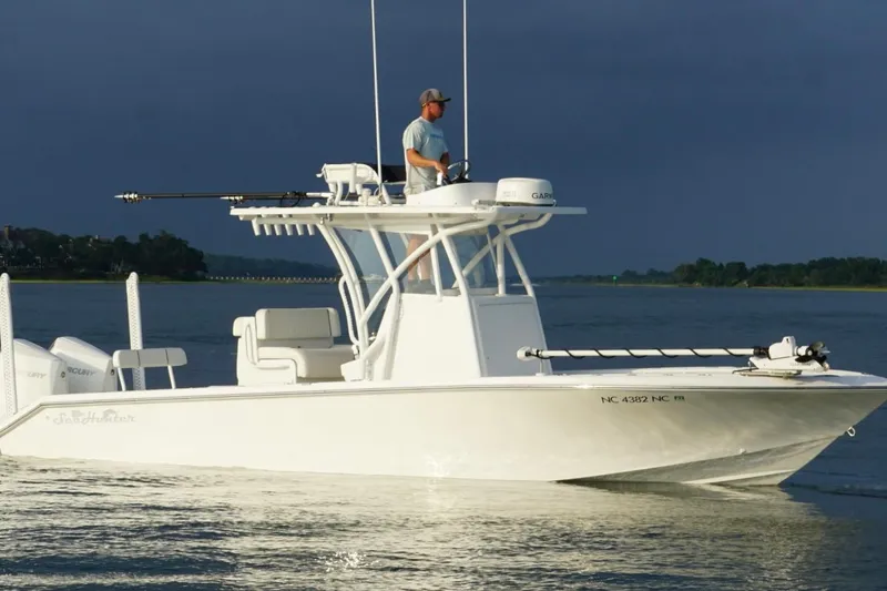 Slide: The Image of 2022 SeaHunter 28 Floridian boat on calm water with a person navigating. - 1