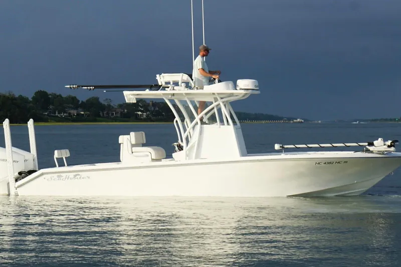 Slide: The Image of 2022 SeaHunter 28 Floridian boat on calm water, with a person navigating. - 12