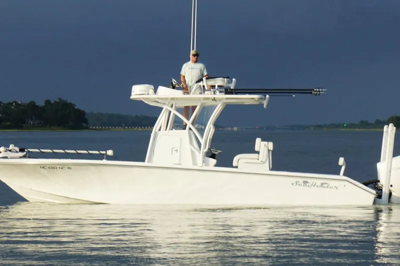 Slide: The Image of 2022 SeaHunter 28 Floridian boat on calm water with a person standing on deck. - 8