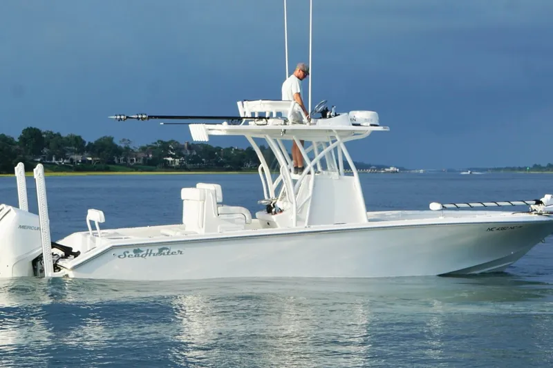 Slide: The Image of 2022 SeaHunter 28 Floridian boat on calm water with a person standing on deck. - 9