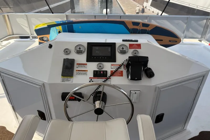 Slide: The Image of Helm of 2025 Sumerset Excellence Multiple Shares houseboat with steering wheel and control panel. - 4