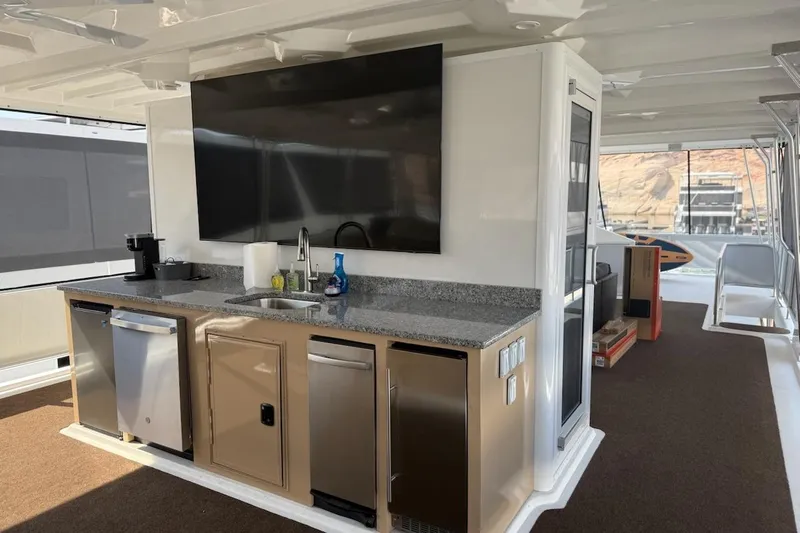 Slide: The Image of Modern kitchen area on 2025 Sumerset Excellence Multiple Shares houseboat, featuring appliances and a large TV. - 8