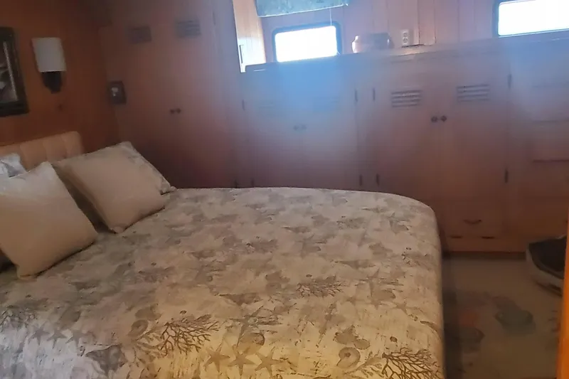 Slide: The Image of Cozy bedroom in 1965 Tacoma Boat Works Bill Garden Motor Yacht, featuring wooden cabinetry and nautical bedding. - 16