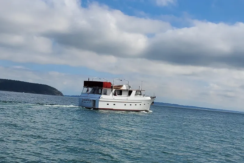 Slide: The Image of 1965 Tacoma Boat Works Bill Garden Motor Yacht cruising on open water under cloudy sky. - 2