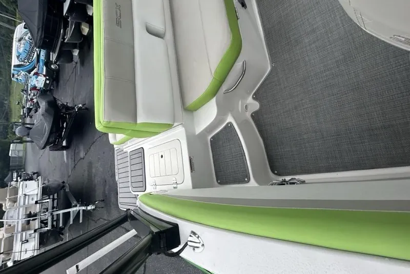 Slide: The Image of 2018 Starcraft 211 I/O SCX boat interior with green and white seating. - 12