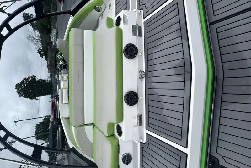 Slide: The Image of 2018 Starcraft 211 I/O SCX boat interior with green and white seating, gray flooring. - 6