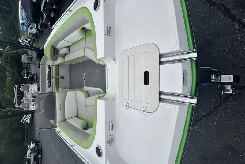 Slide: The Image of 2018 Starcraft 211 I/O SCX boat with green accents, spacious seating, and sleek design. - 8