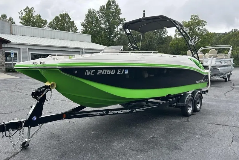 Slide: The Image of 2018 Starcraft 211 I/O SCX boat with green and black design on a trailer. - 4