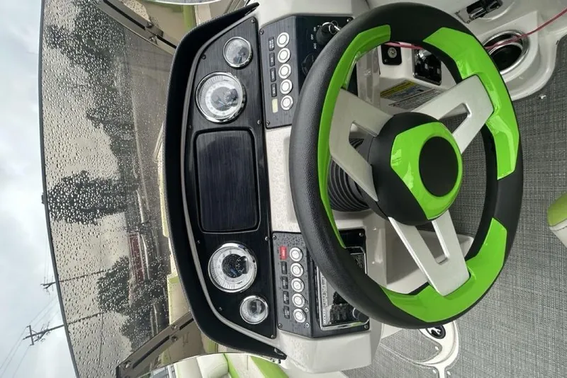 Slide: The Image of 2018 Starcraft 211 I/O SCX boat dashboard with green-accented steering wheel. - 9