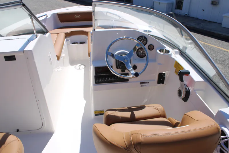 Slide: The Image of 2026 Key West 203 DFS boat interior with tan seating and modern dashboard controls. - 10