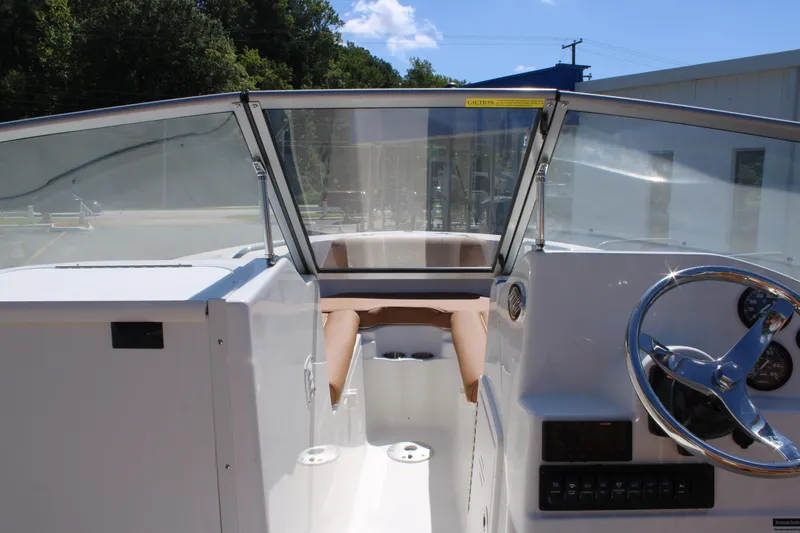 Slide: The Image of 2026 Key West 203 DFS boat interior with steering wheel and seating area. - 13