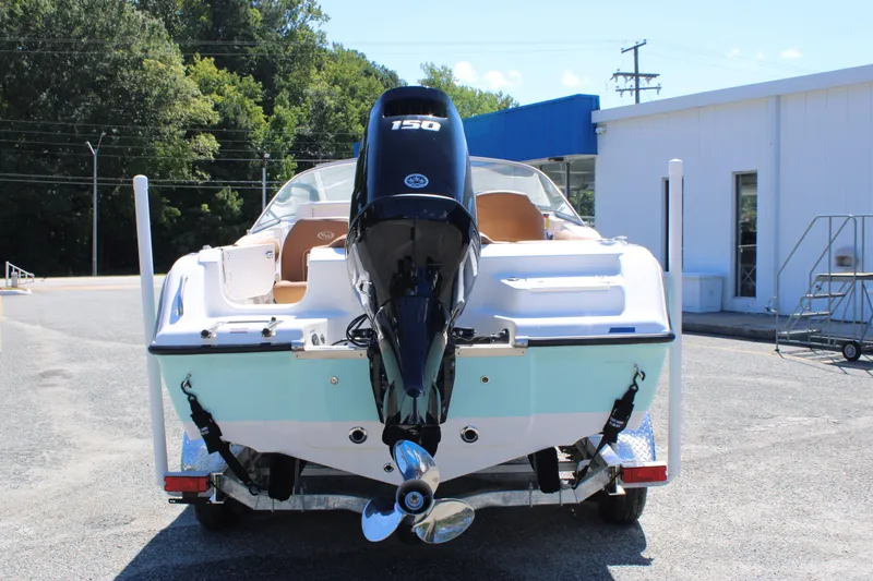 Slide: The Image of 2026 Key West 203 DFS boat with 150 HP outboard motor, parked outdoors. - 2
