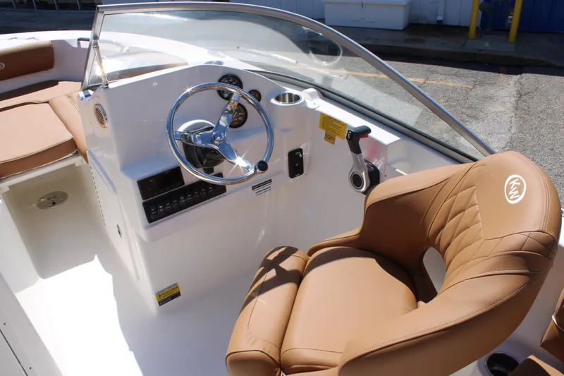 Slide: The Image of 2026 Key West 203 DFS boat interior with steering wheel and tan seating. - 22