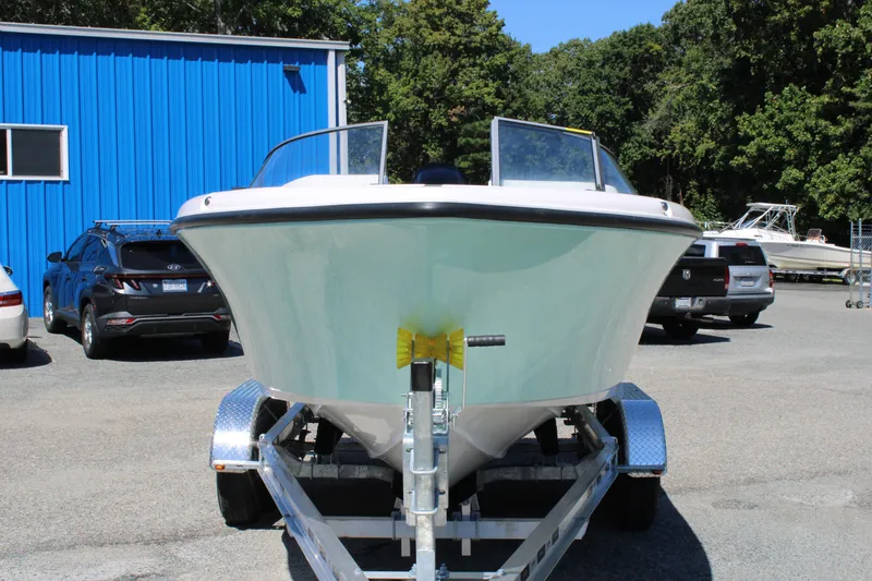 Slide: The Image of 2026 Key West 203 DFS boat on trailer in parking lot, blue building background. - 4