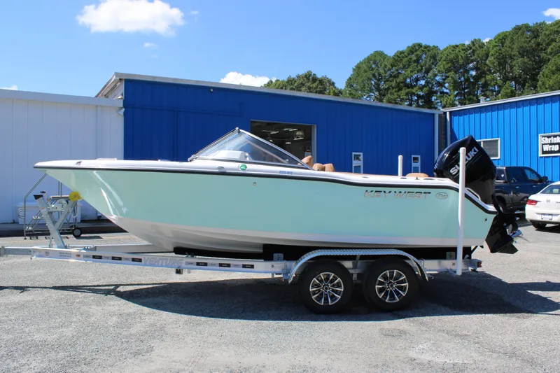 Slide: The Image of 2026 Key West 203 DFS boat on trailer, parked outside blue building. - 5