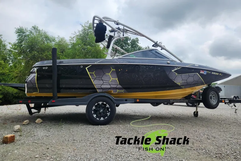 The Image of 2006 MasterCraft MariStar 200 boat on trailer, featuring a sleek design and custom graphics. - 0