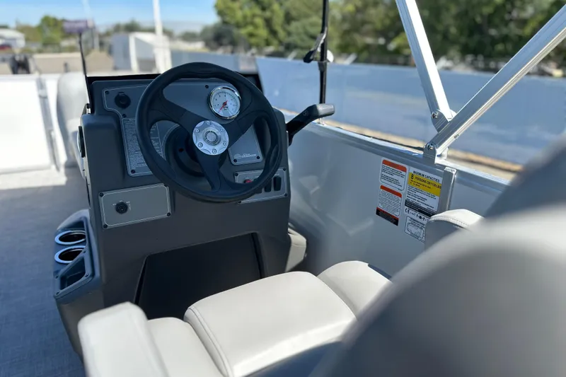 Slide: The Image of 2026 Sun Tracker Party Barge 16 DLX steering console with gauges and controls. - 14