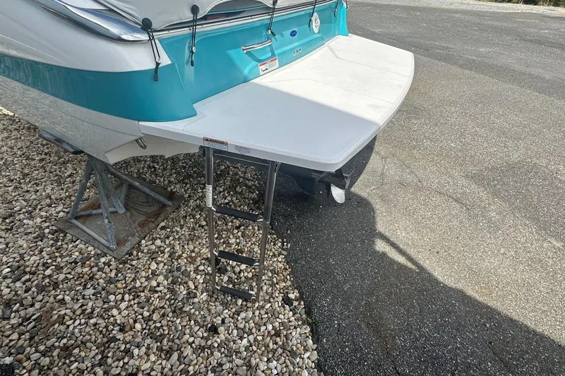 Slide: The Image of 2020 Regal LS4 boat with swim platform and ladder on gravel and pavement. - 10