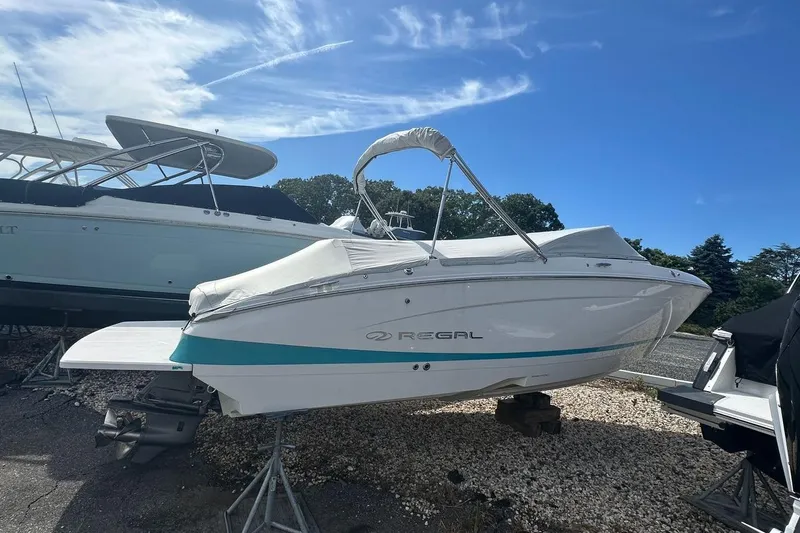 Slide: The Image of 2020 Regal LS4 boat on display, covered and elevated, under a clear blue sky. - 14