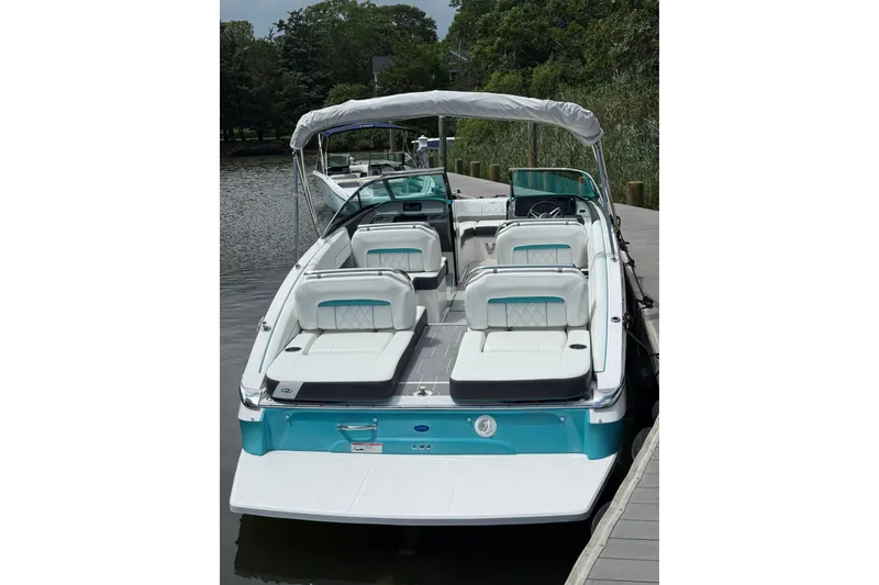 Slide: The Image of 2020 Regal LS4 boat with white seating and teal accents docked by the water. - 4