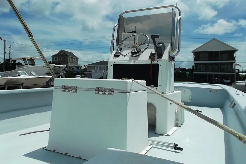 Slide: The Image of 2008 Hancock 22 boat with steering console, docked under a clear blue sky. - 4