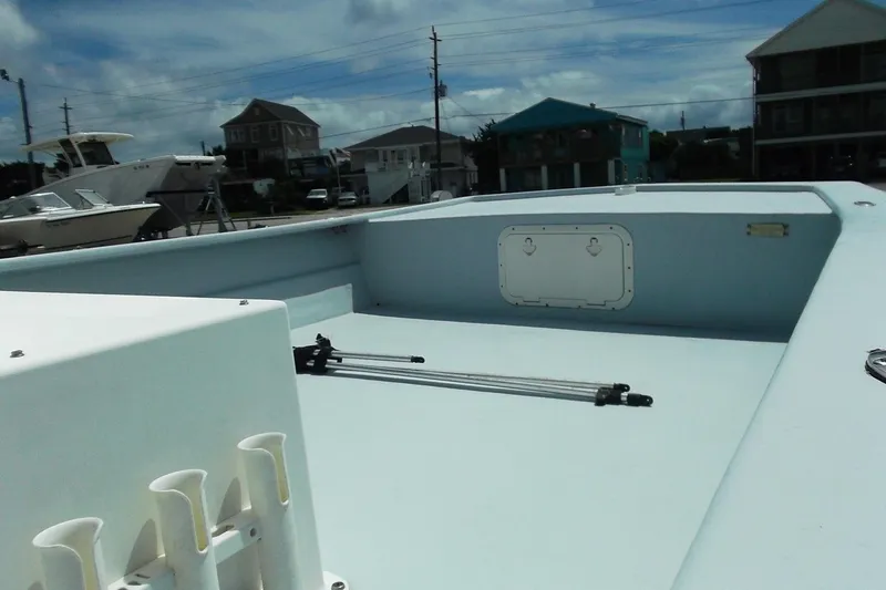 Slide: The Image of 2008 Hancock 22 boat deck with storage hatch, docked near other boats and buildings. - 5