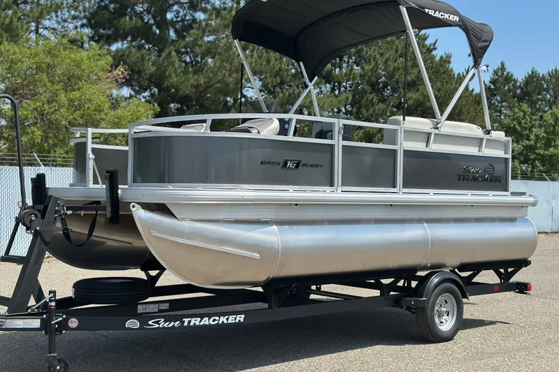 Slide: The Image of 2026 Sun Tracker Bass Buggy 16 DLX pontoon boat on trailer, outdoors. - 3
