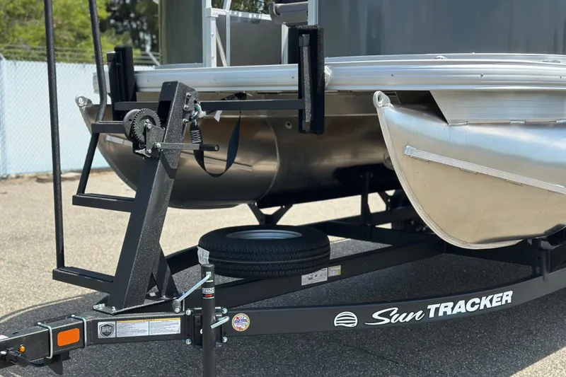Slide: The Image of 2026 Sun Tracker Bass Buggy 16 DLX pontoon boat on trailer, close-up view. - 4
