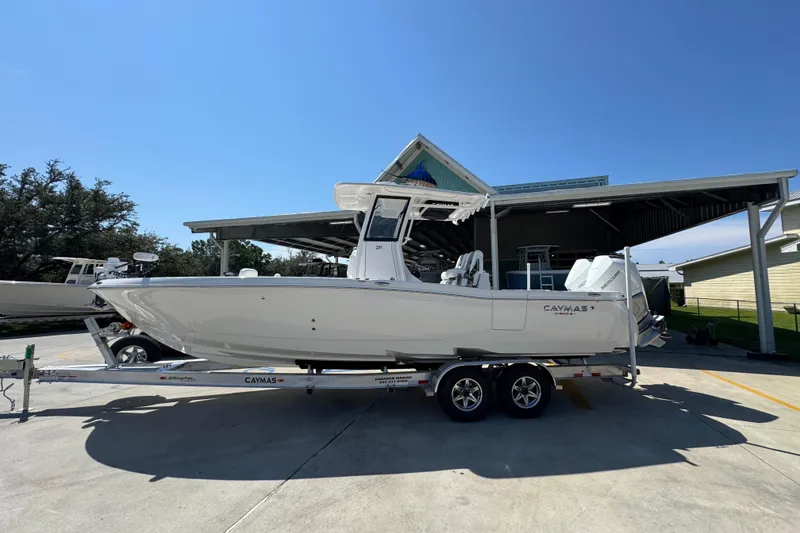 The Image of 2026 Caymas 291 boat on trailer, parked outdoors under clear blue sky. - 1