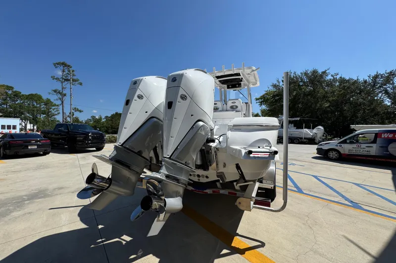 Slide: The Image of 2026 Caymas 291 boat with dual outboard motors in a parking lot. - 12
