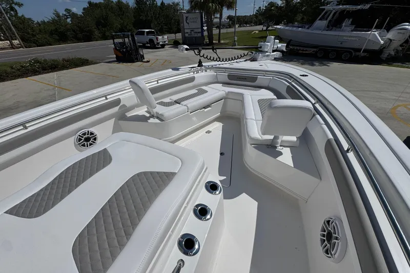 Slide: The Image of 2026 Caymas 291 boat interior with white and gray seating, cup holders, and speakers. - 17
