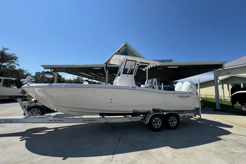 Slide: The Image of 2026 Caymas 291 boat on trailer under clear blue sky. - 2