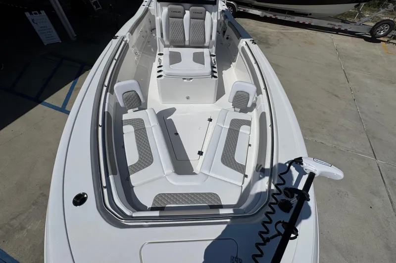 Slide: The Image of 2026 Caymas 291 boat interior with gray and white seating, docked on concrete. - 21