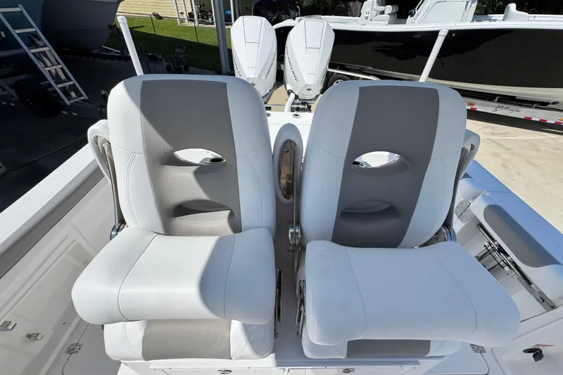Slide: The Image of 2026 Caymas 291 boat seats, white and gray, with outboard motors in background. - 28