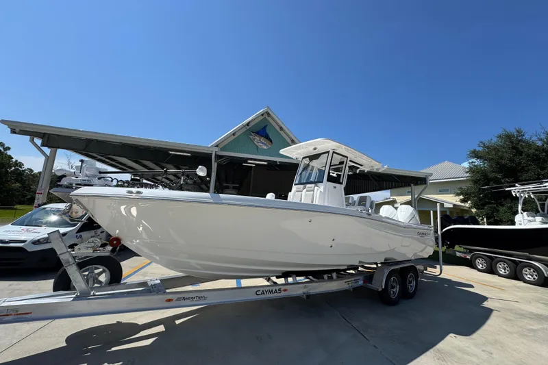 Slide: The Image of 2026 Caymas 291 boat on trailer under clear blue sky. - 3