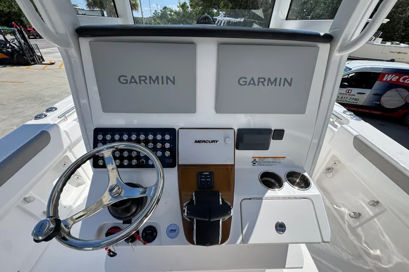 Slide: The Image of 2026 Caymas 291 boat dashboard with Garmin displays and Mercury controls. - 30
