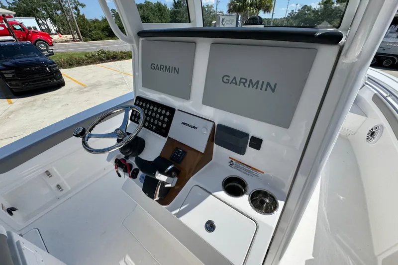 Slide: The Image of 2026 Caymas 291 boat dashboard with dual Garmin displays and steering wheel. - 32