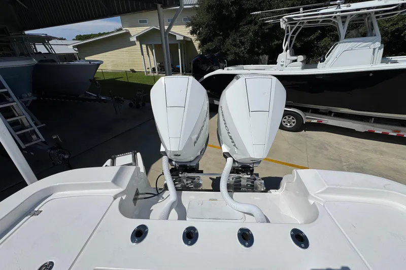 Slide: The Image of 2026 Caymas 291 boat with dual Mercury outboard engines in a marina setting. - 37
