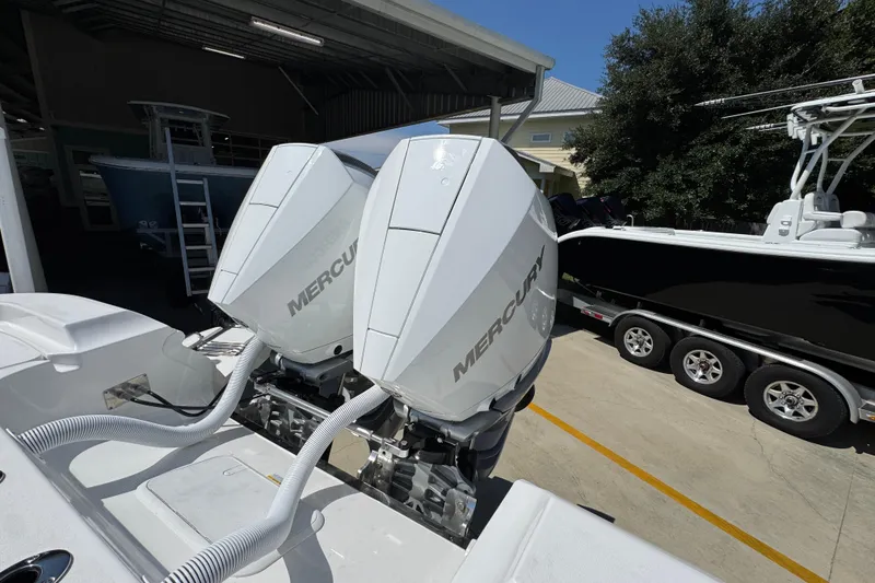 Slide: The Image of Twin Mercury outboard engines on a 2026 Caymas 291 boat, parked in a marina. - 38