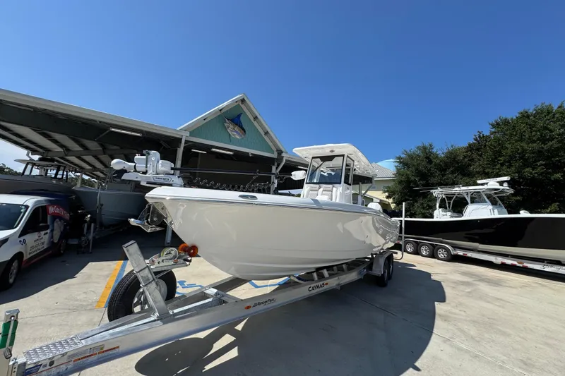 Slide: The Image of 2026 Caymas 291 boat on trailer, parked outdoors under clear blue sky. - 4