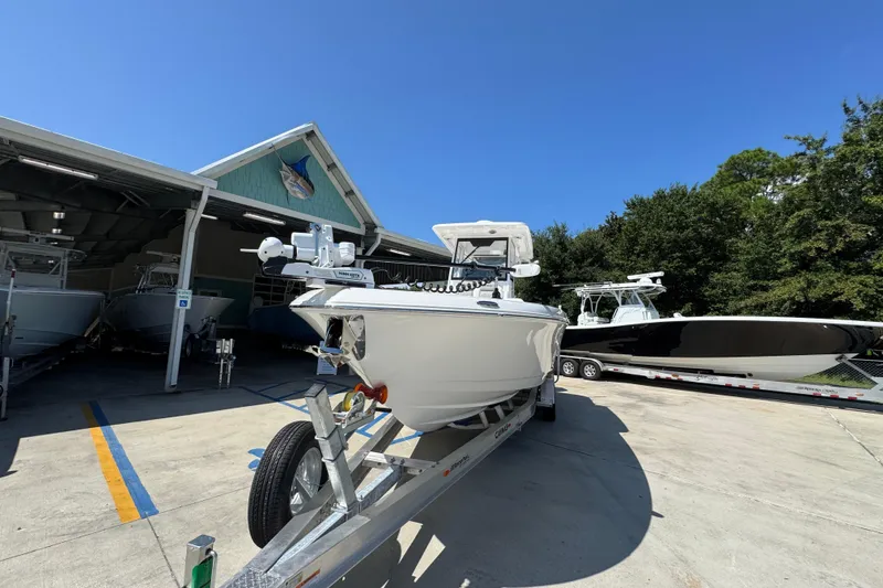 Slide: The Image of 2026 Caymas 291 boat on trailer outside a marina under clear blue sky. - 5