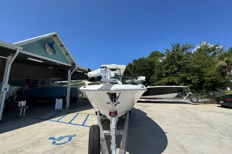 Slide: The Image of 2026 Caymas 291 boat on trailer at dealership under clear blue sky. - 6