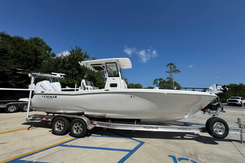 Slide: The Image of 2026 Caymas 291 boat on trailer, parked outdoors under clear blue sky. - 9