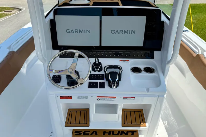 Slide: The Image of 2026 Sea Hunt Ultra 305 SE boat dashboard with dual Garmin displays and steering wheel. - 10