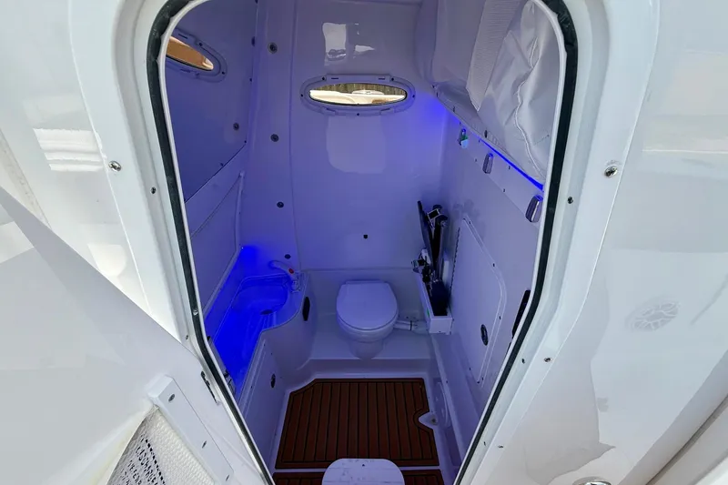 Slide: The Image of 2026 Sea Hunt Ultra 305 SE boat interior with modern bathroom and blue LED lighting. - 13
