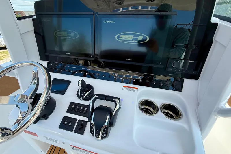 Slide: The Image of Control panel of 2026 Sea Hunt Ultra 305 SE with dual Garmin displays and steering wheel. - 17